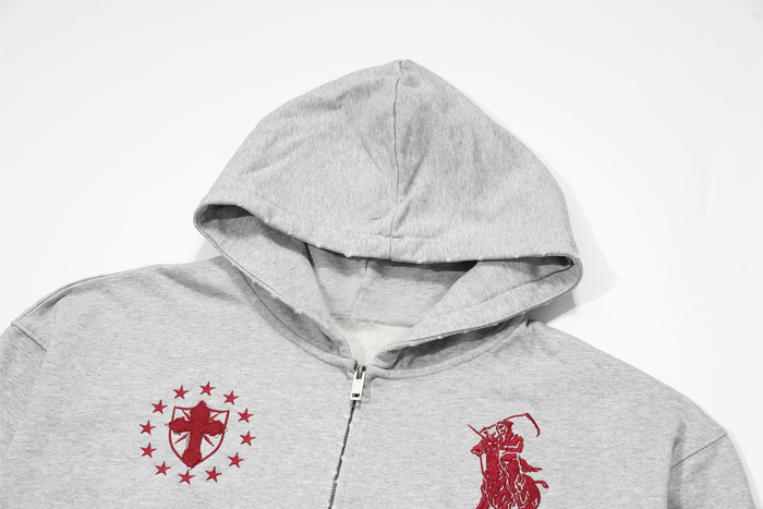 Close-up of light gray hoodie hood and upper front with red embroidered crest details