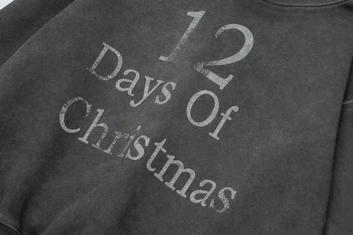 Close-up of black hoodie front with worn 12 Days Of Christmas text print