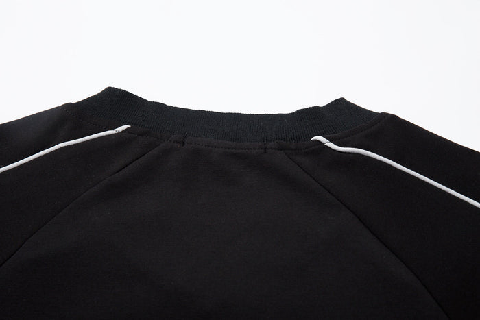 Black V-neck collar and shoulder seam detail on the raglan top