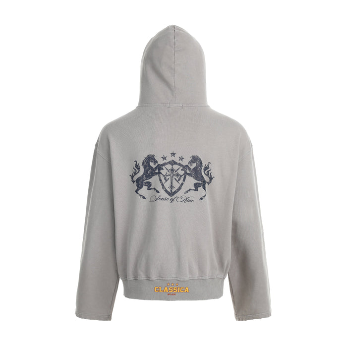 Light gray washed hoodie back view with dark crest graphic and ribbed hem