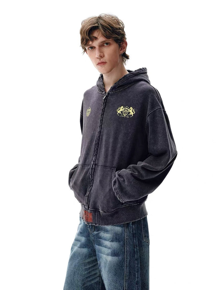 Dark washed zip hoodie worn by model, front angled view with crest prints