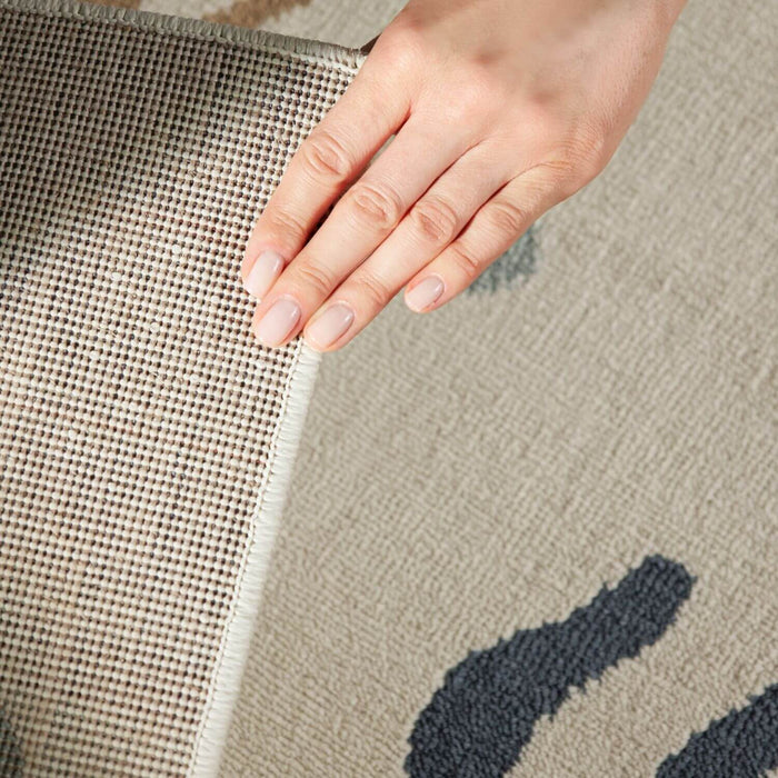 Hand touching the edge of two different textured rugs.