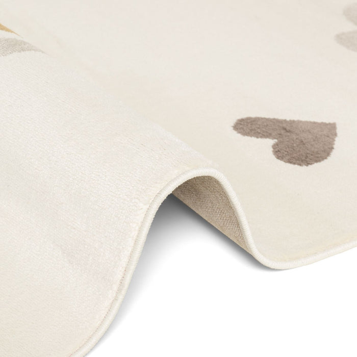 Close-up of a beige rug with heart patterns on a white background