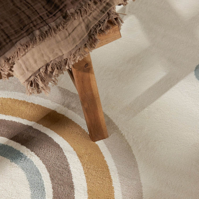 Close-up of a wooden stool with a textured brown fabric on a patterned rug.