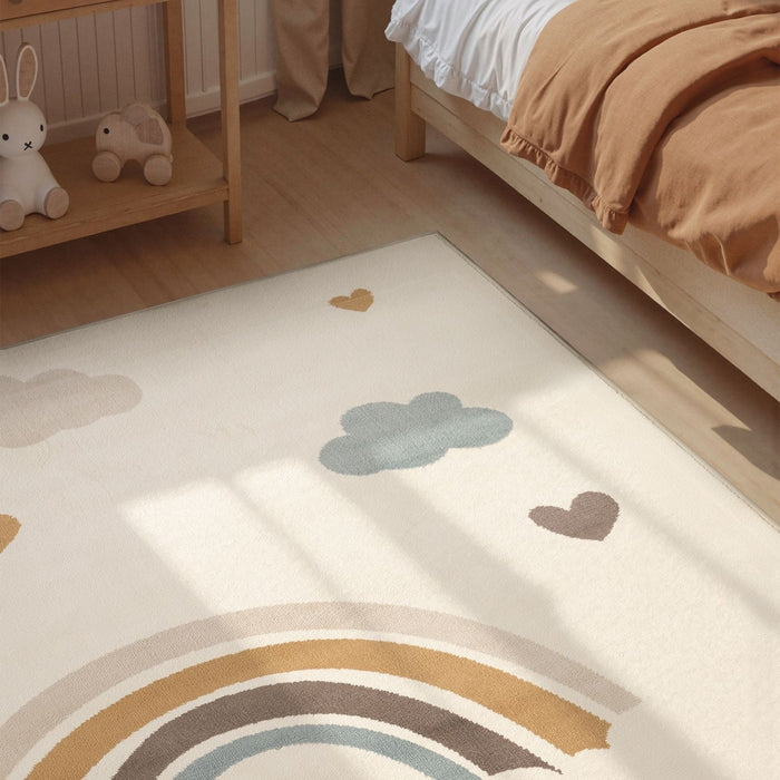 Children's room with a rug featuring rainbow and cloud designs.