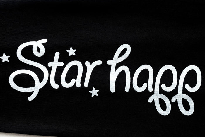 Black sleeve close-up with white stylized 'Star happ' lettering
