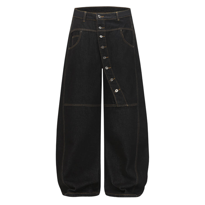 Front view of black wide-leg denim pants with asymmetric button placket and orange topstitching