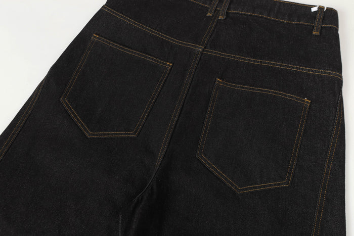 Back view close-up of black denim pants with patch pockets and topstitched seams