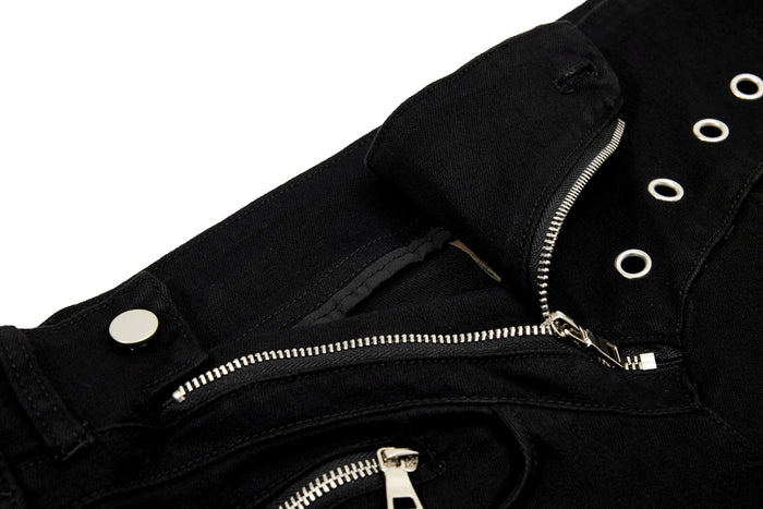 Close-up of front pocket and diagonal zipper on black pants