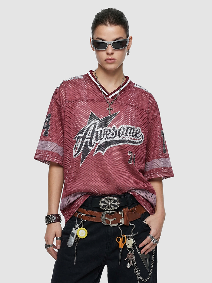 Model wearing a maroon mesh jersey T-shirt with Awesome graphic, V-neck trim, and relaxed retro varsity streetwear fit