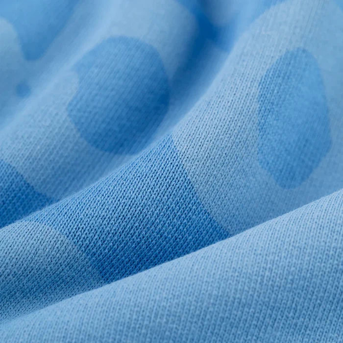 Close-up of the Sp5der Star Hoodie in Baby Blue, showcasing its darker blue polka dot pattern. The heavyweight 440GSM cotton fleece feels cozy, while gentle folds highlight the oversized streetwear pullover’s soft texture.