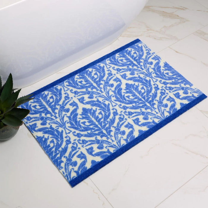 Blue and white patterned bath mat on a tiled bathroom floor.