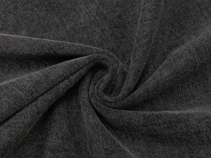 Close-up of washed black tee fabric with a soft denim-like texture and spiral drape detail