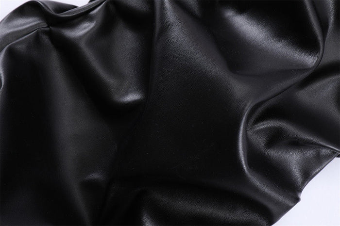 Close-up of black faux leather with a smooth shiny texture and soft creases