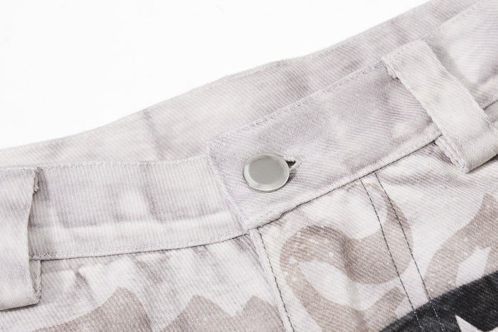 Close-up of light denim waistband with silver button and faded print