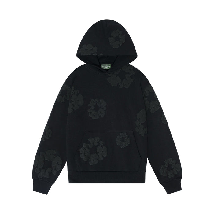 The Black Monochrome “Cotton Wreath” Denim Tears Hoodie is a minimal streetwear sweatshirt featuring a front pocket and subtle black floral patterns scattered across the fabric.