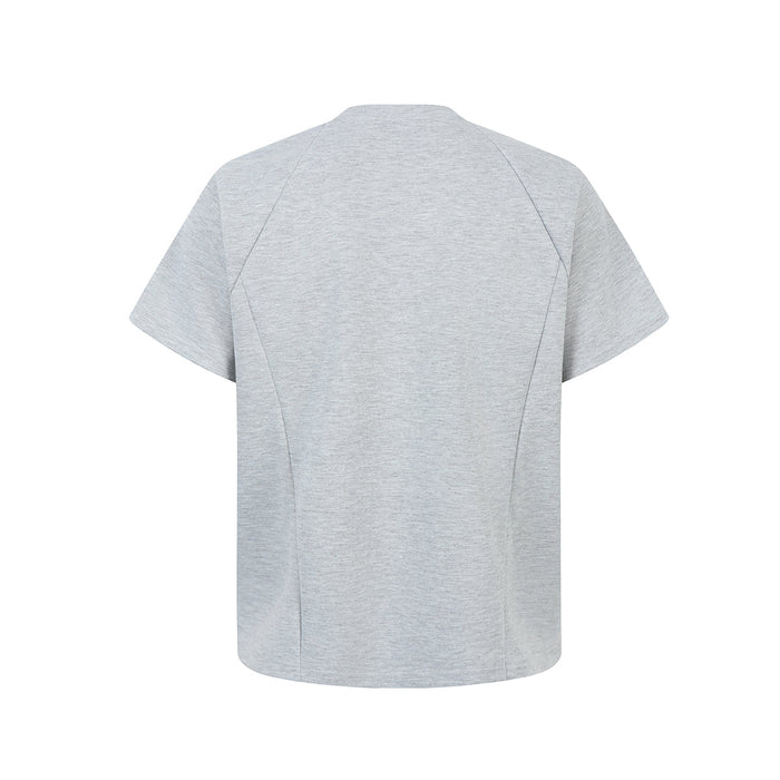 Light gray oversized tee with geometric seam panels and a minimal structured cut, shown flat on white background