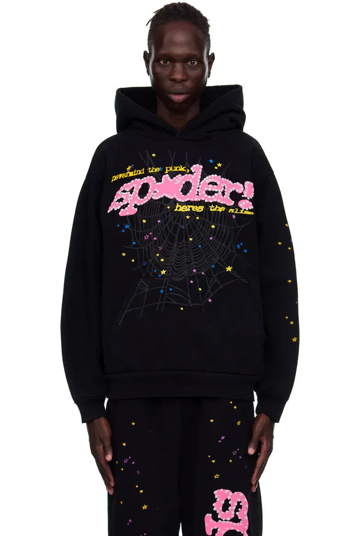 A person wears the Sp5der “Hares the Slime” Hoodie in black—made from 440GSM heavyweight cotton fleece with colorful “spider!” text, a spiderweb, and yellow stars—standing against a plain white background.