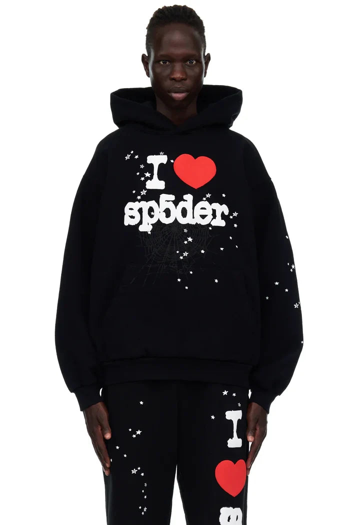 Wearing the Sp5der "I Love Sp5der" Hoodie – Black Web 440GSM Heavyweight Streetwear Pullover and matching pants, both featuring white star patterns and bold “I ❤️ sp5der” text, this look pops against a clean white background.