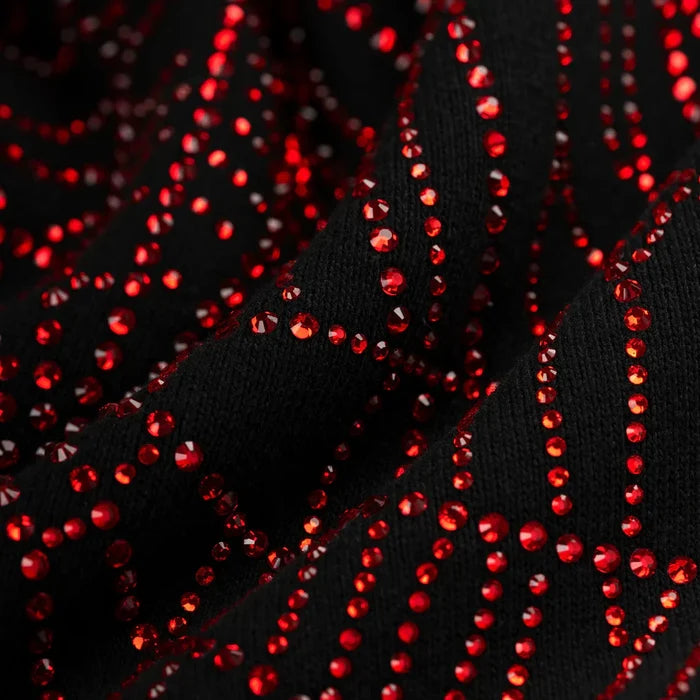 Close-up of the Sp5der Rhinestone Web Hoodie—Black 440GSM heavyweight cotton fleece—featuring wavy, shiny red rhinestones in a zigzag pattern, reflecting the bold, textured sparkle of luxury streetwear.