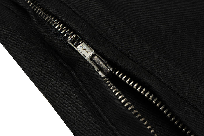 Close-up of black zipper pull and metal teeth on denim