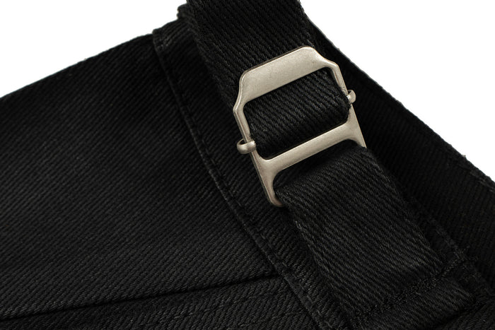 Black denim waistband with adjustable strap and silver buckle close-up