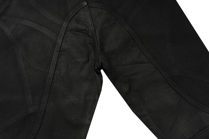 Close-up of black jeans back panel and curved seam detail