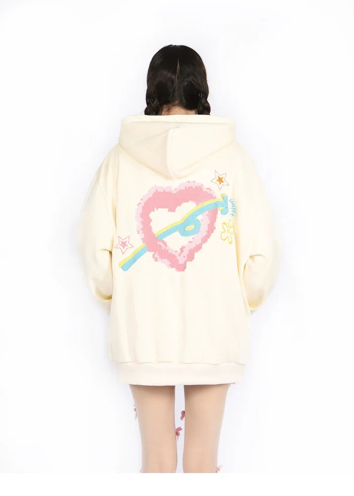 Someone wearing the Seakoff Kawaii Pastel Cartoon Hoodie with a pixelated heart and planet design stands back to the camera. This cream hoodie features pink and blue accents, small stars, and embodies anime fashion for a charming look.