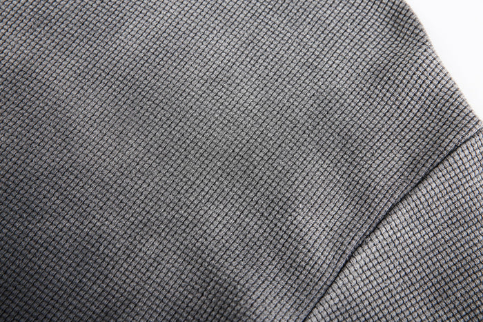 Close-up of gray-black waffle knit fabric texture on the shoulder seam