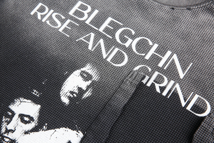Close-up of front graphic text on black waffle knit long sleeve tee
