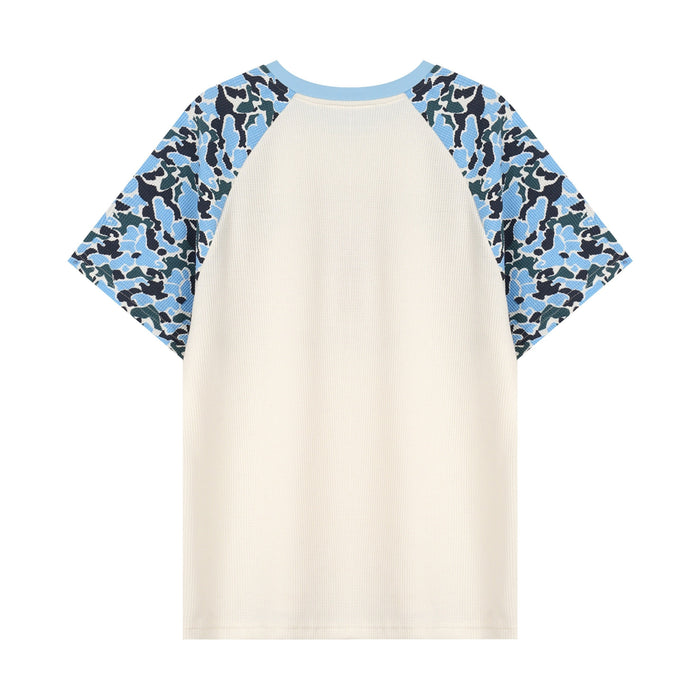 Cream raglan graphic T-shirt with blue camo sleeves and light blue trim on a white background