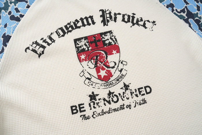 Camo raglan graphic T-shirt with distressed crest print and black varsity lettering on cream fabric