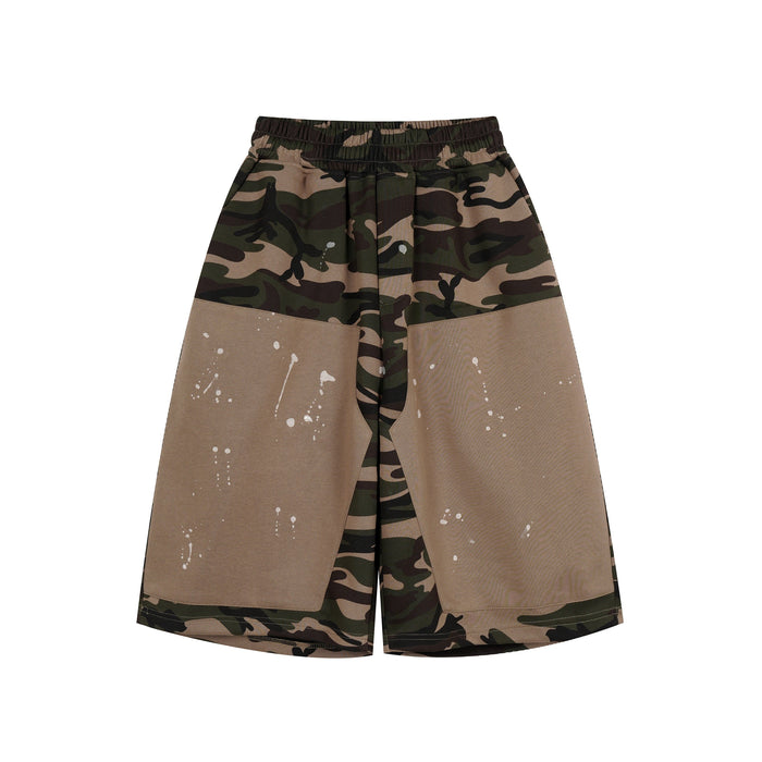 Front view of camo patchwork baggy shorts with tan panels and white paint splatter