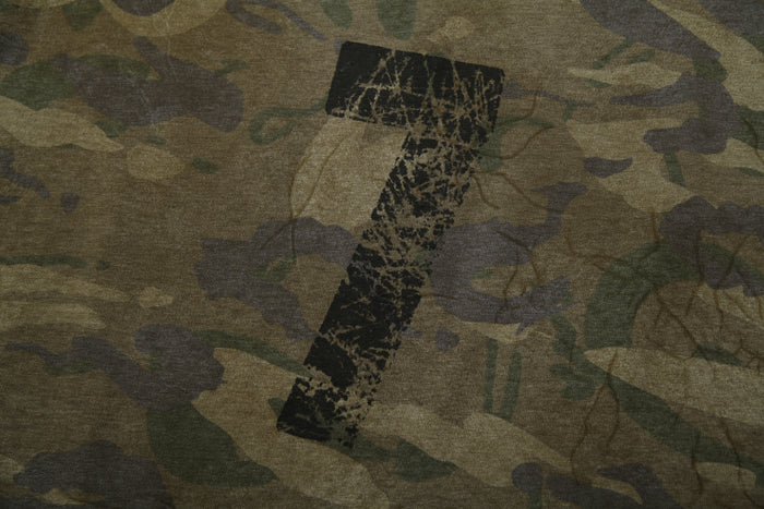 Close-up of large distressed number graphic on camo patchwork long sleeve tee