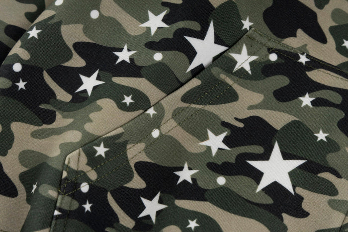 Close-up of camo fabric with white star print and front pocket seam