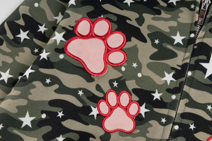 Close-up of pink paw patch appliqués on camo hoodie front near the zipper