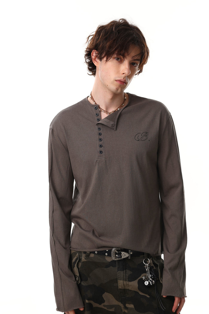 Model wearing brown Henley long sleeve T-shirt with button placket and chest logo