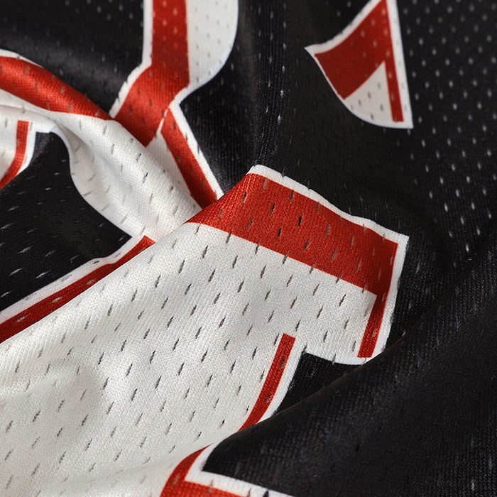 Close-up of a black mesh football jersey with bold red and white varsity number detailing and stitched athletic fabric texture