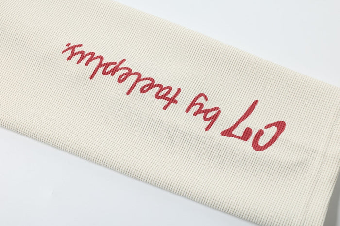 Red script text printed on cream sleeve of the tee
