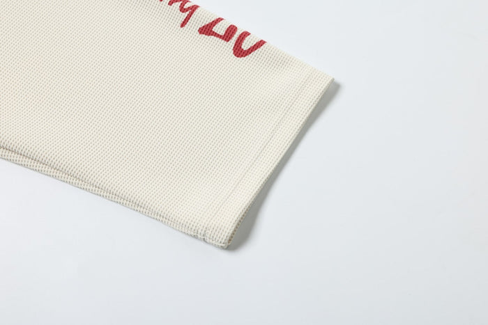 Lower sleeve hem detail on cream textured long sleeve tee