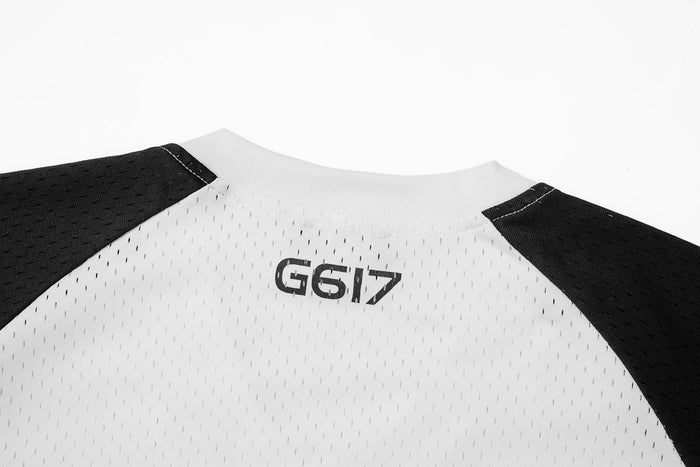 Close-up of jersey back neckline showing G617 logo on white mesh fabric with black shoulders