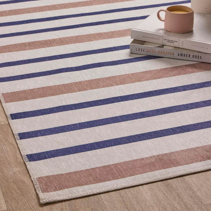 Striped rug with blue and brown stripes on a wooden floor