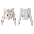 White cropped off-shoulder zip hoodie with red distressed star prints, script lettering, and red double sleeve stripes, shown