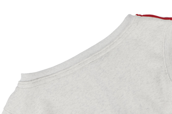 Side close-up of white hoodie shoulder and red double stripe sleeve detail
