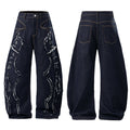 Front and back view of dark indigo baggy jeans with frayed white flame appliqué panels and contrast stitching