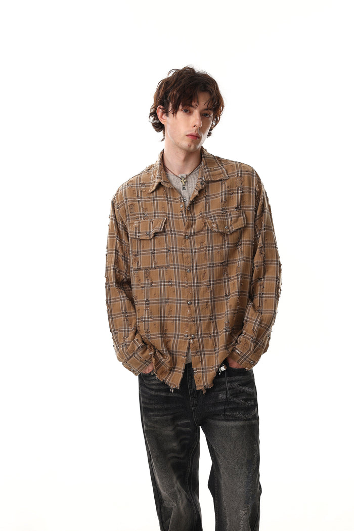 Model wearing tan distressed plaid shirt jacket over a gray top