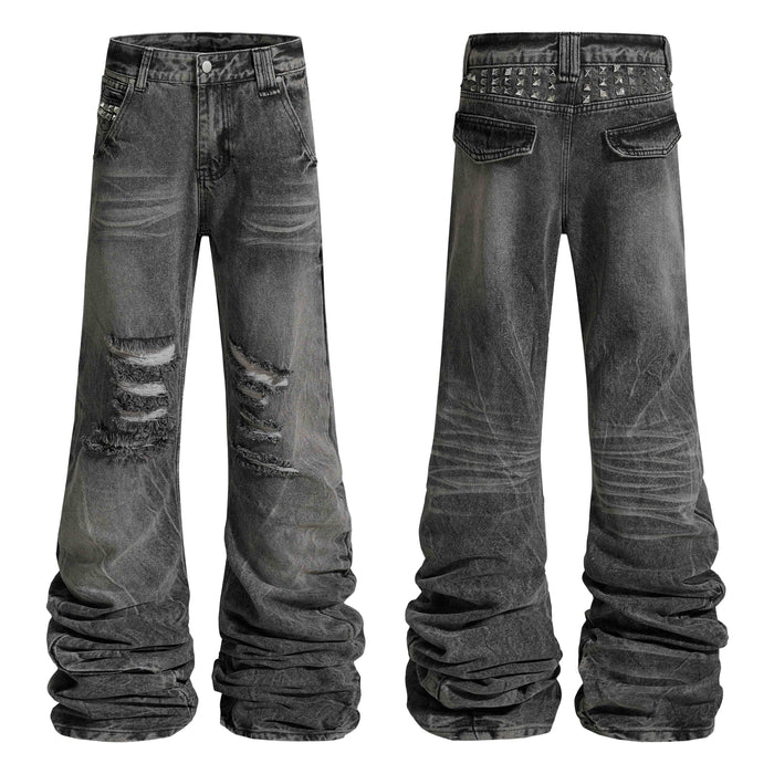 Front and back view of grey distressed studded stacked denim jeans with ripped knees and pyramid stud waistband