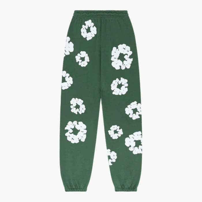 Forest Green “Cotton Wreath” Denim Tears sweatpants with an elastic waistband and cuffs, featuring a scattered large white floral print for a standout streetwear look.