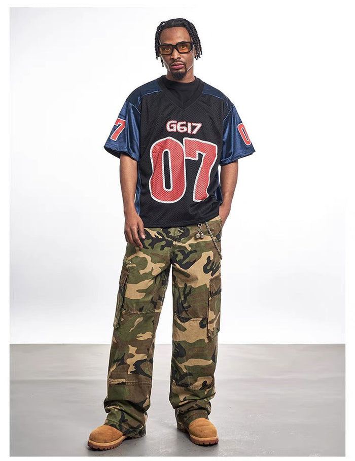 Oversized black mesh varsity jersey tee with bold red 07 graphic and blue sleeves, styled on model with cargo pants