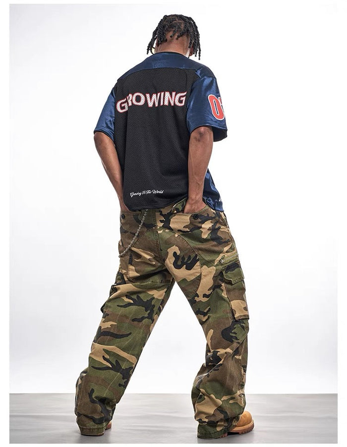 Oversized black and blue mesh varsity jersey tee with bold back lettering, styled with camo cargo pants